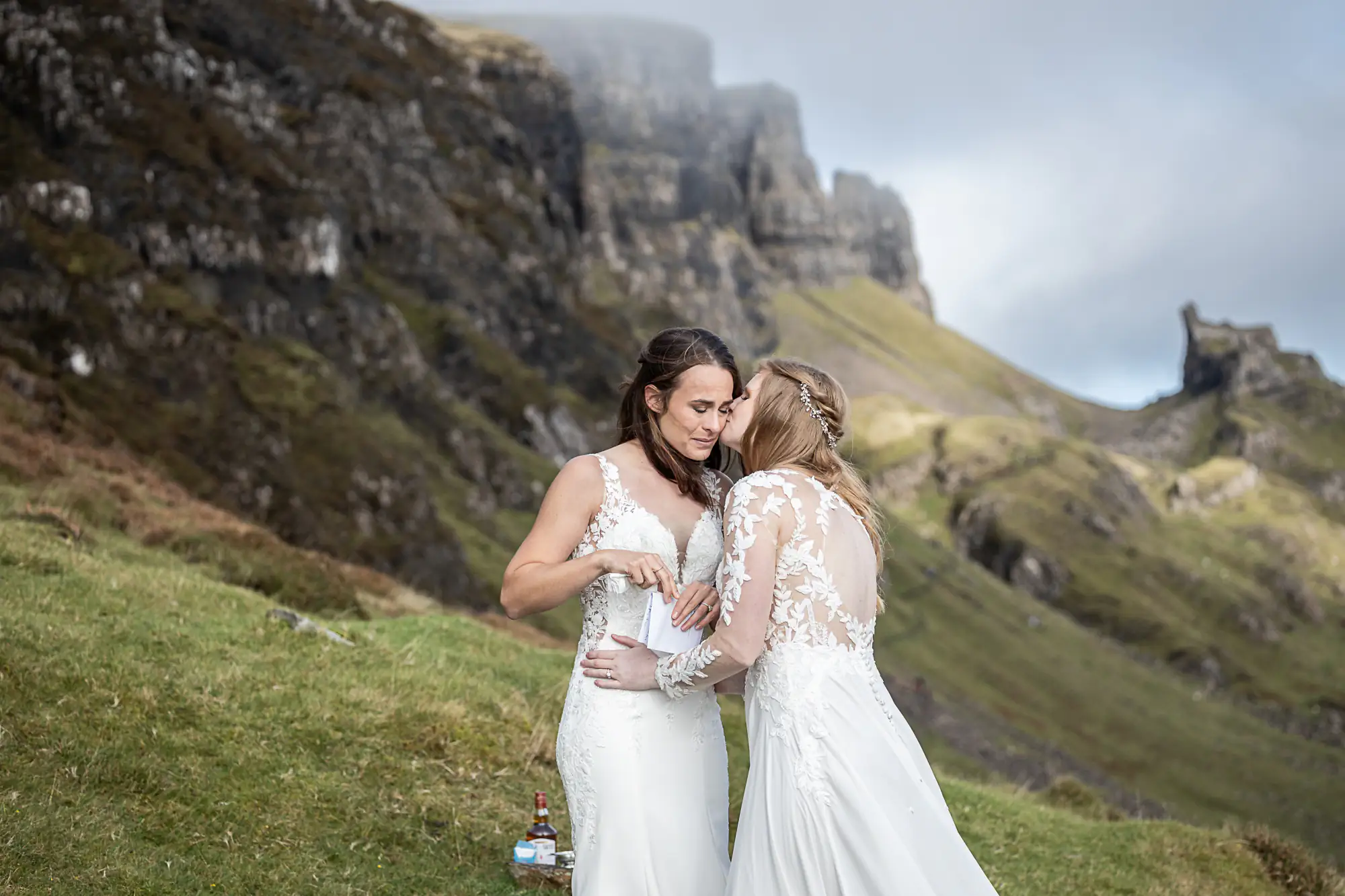 bride kisses her bride on the cheek