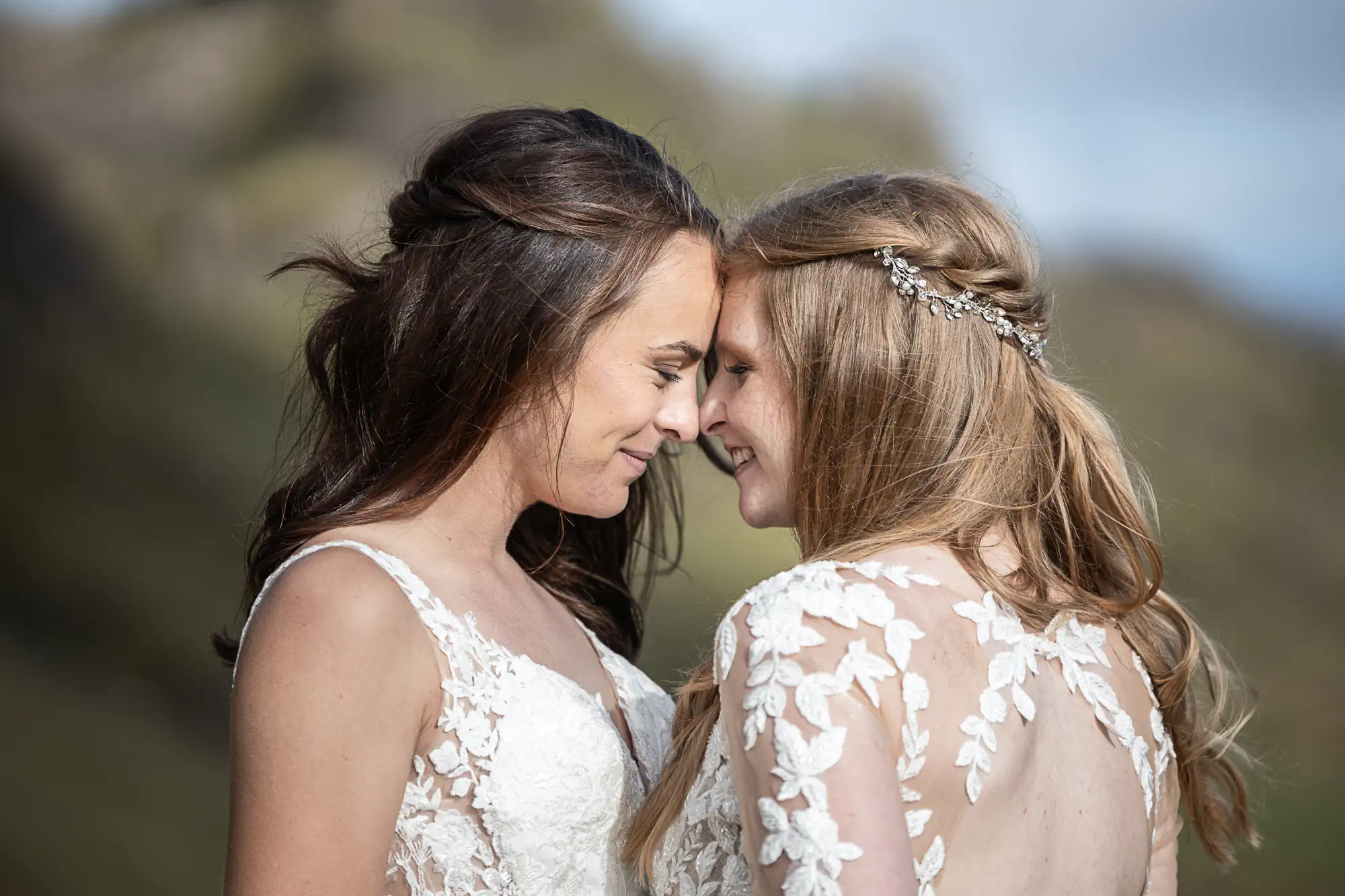 brides in white dresses embrace