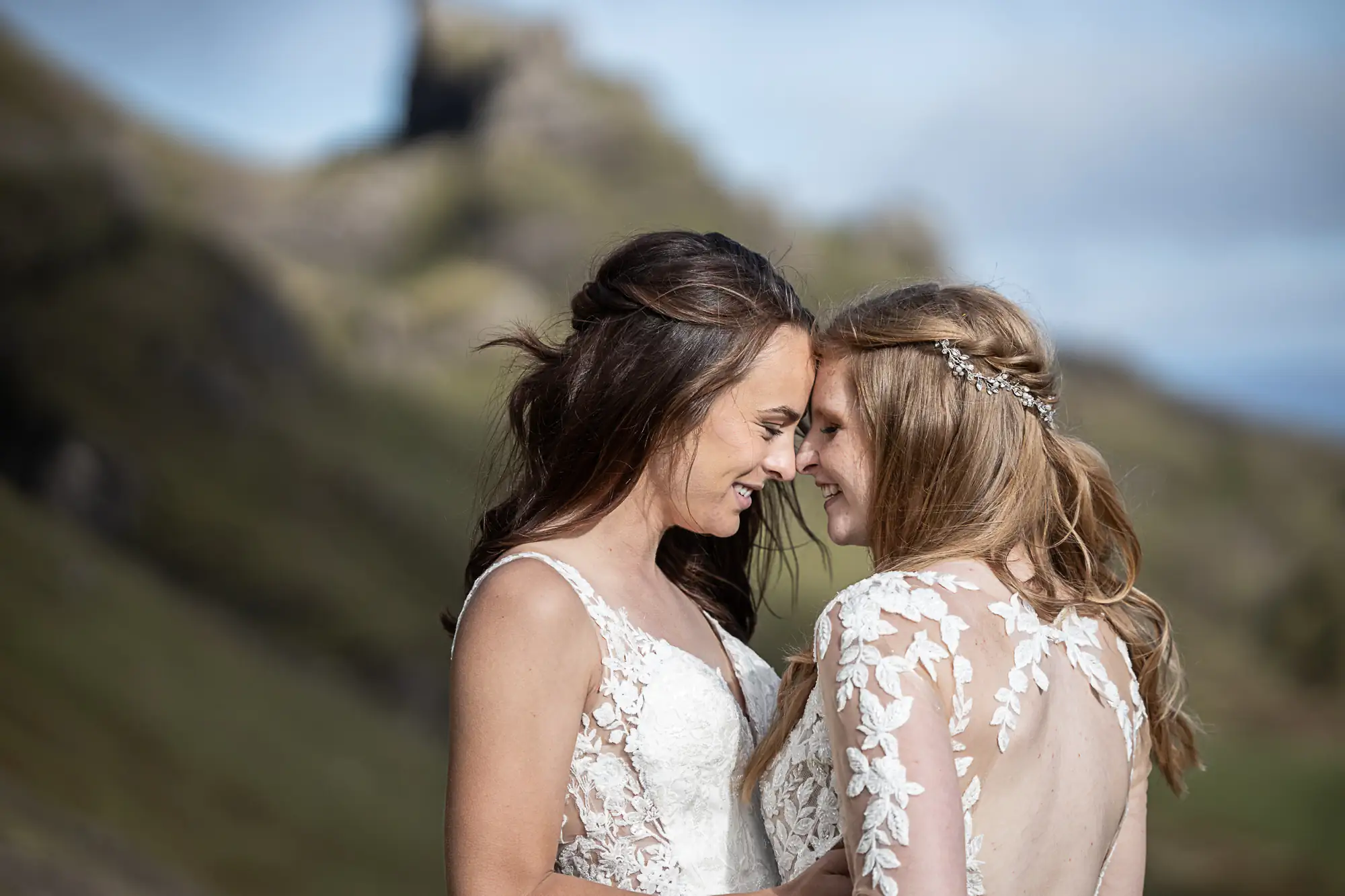 brides in white dresses embrace