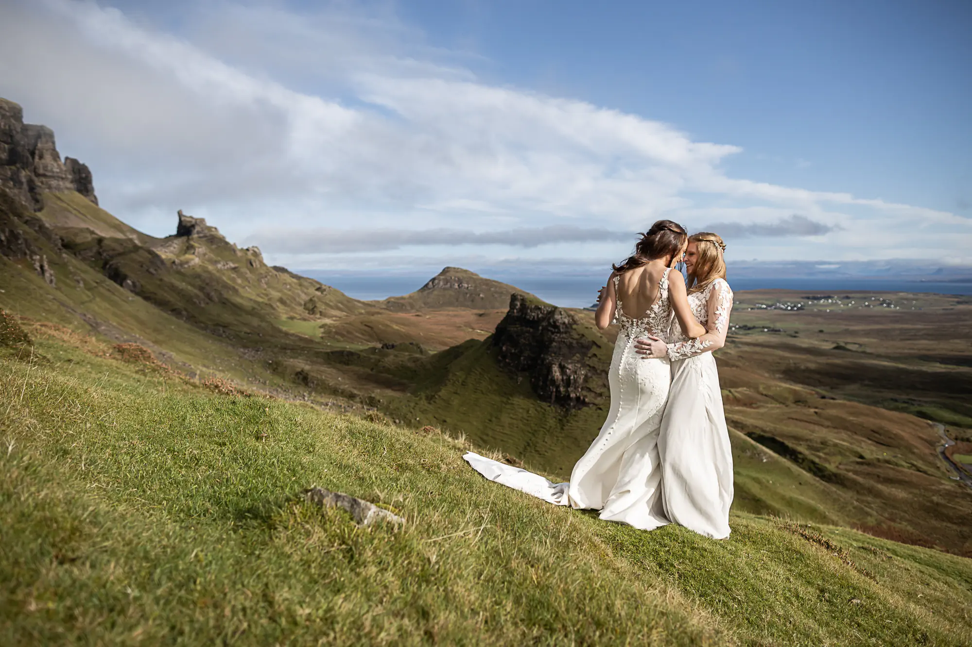 brides cuddle on the side of a mountain