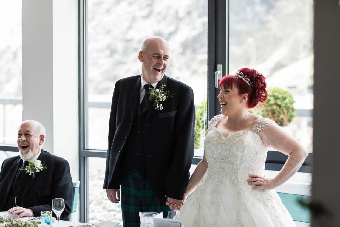 bride and groom laughing at top table