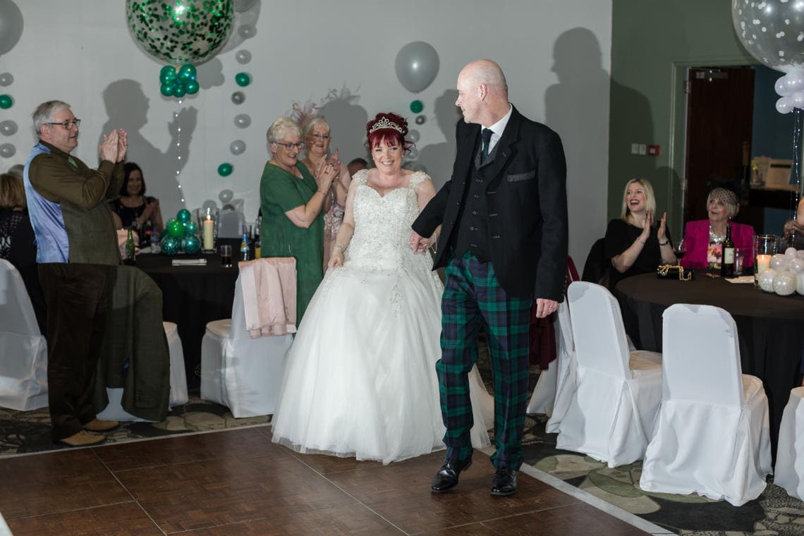 bride and groom enter evening reception to rapturous applause