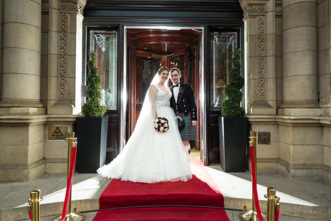 Newlyweds on the red carpet at the entrance to the hotel