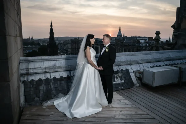Bride and groom on an Edinburgh rooftop at dusk