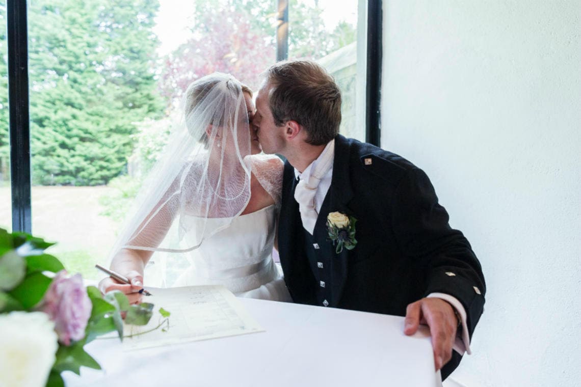 newlyweds kiss after signing the marriage schedule in The Chapel