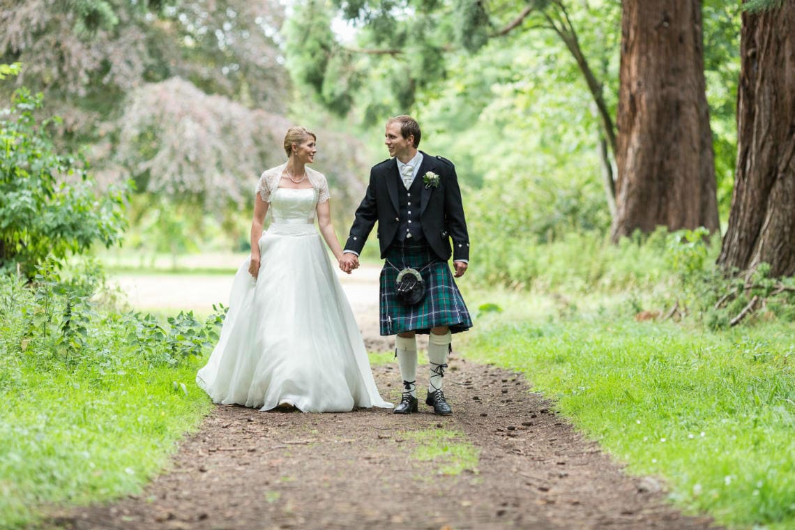newlyweds walking beneath the giant Redwood trees