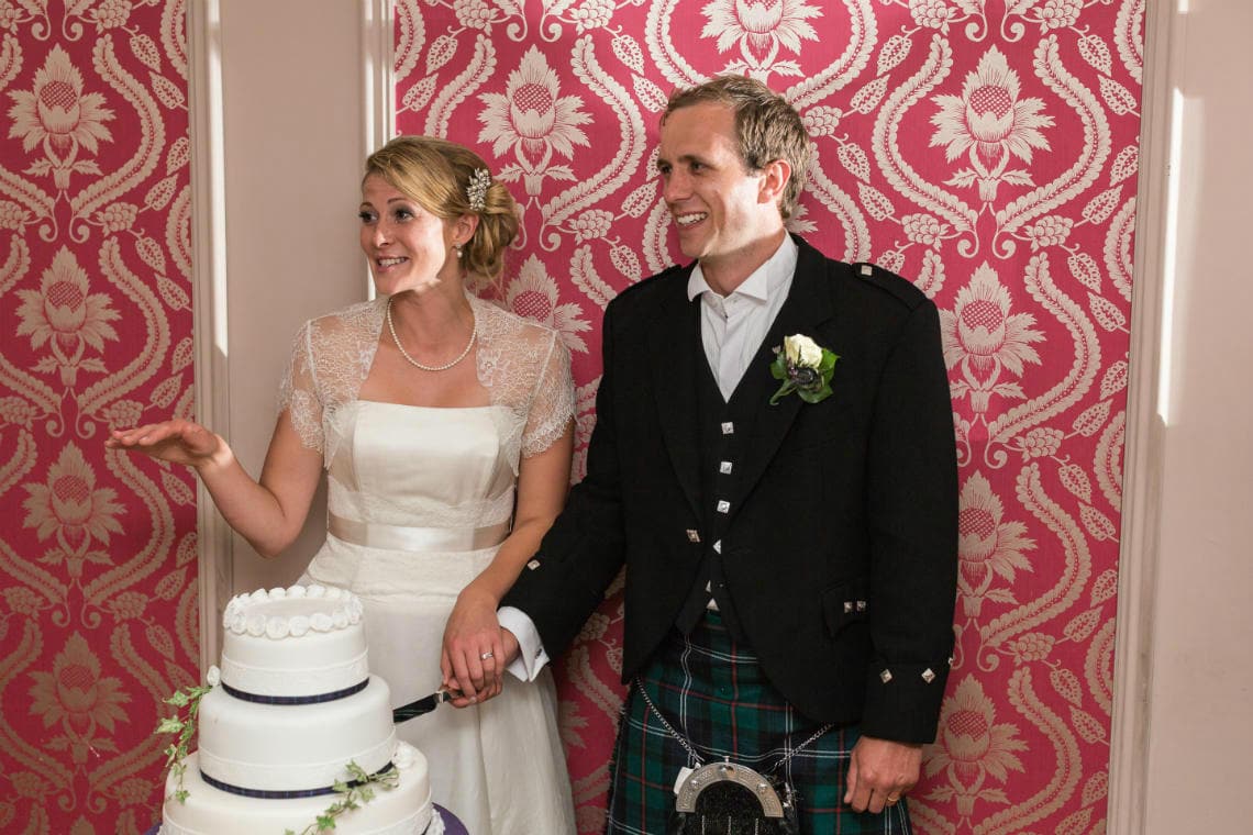 newlyweds cutting the cake in the Rose Garden Room
