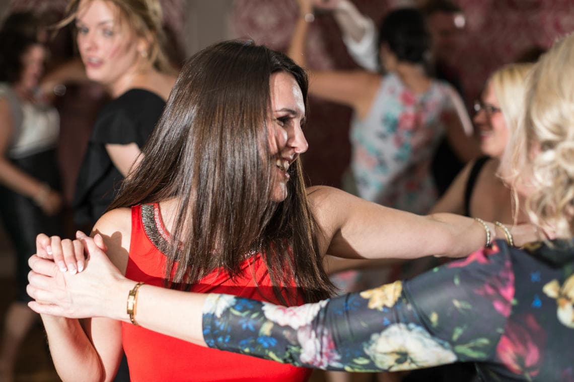 Girl in a red dress dancing during the evening reception in the Rose Garden Room