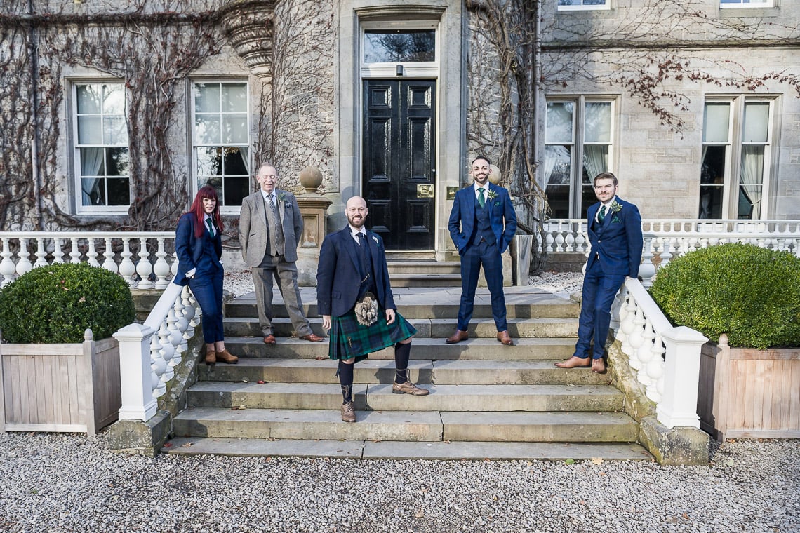 groom and best men standing on the steps at the entrance