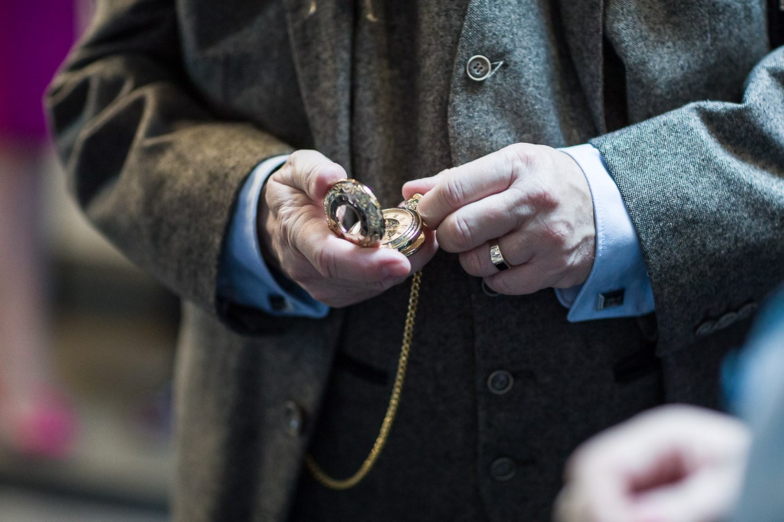 man checking the time on an antique watch