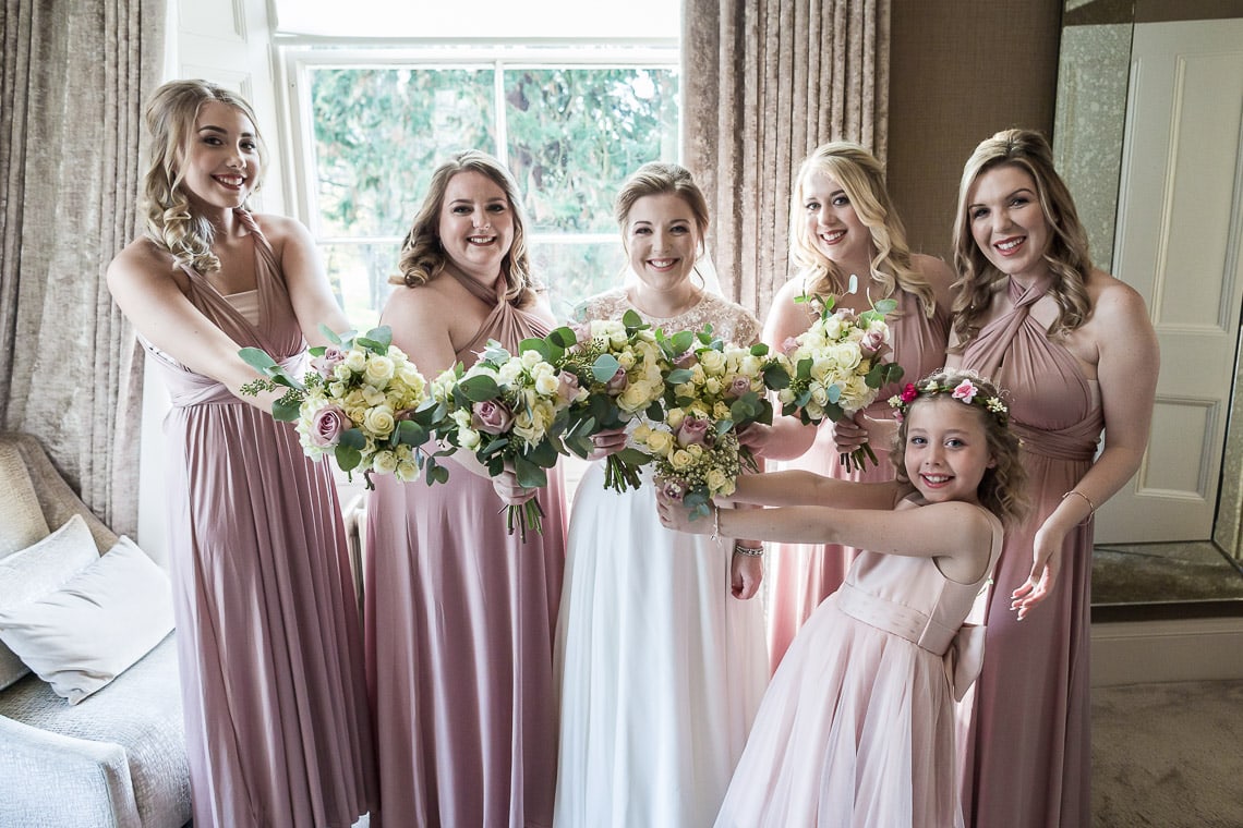 bride, bridesmaids and flower girl pre-ceremony group photo in bedroom