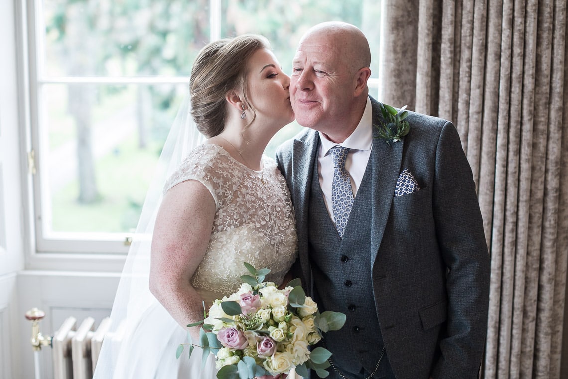 bride kisses her father on the cheek pre-ceremony
