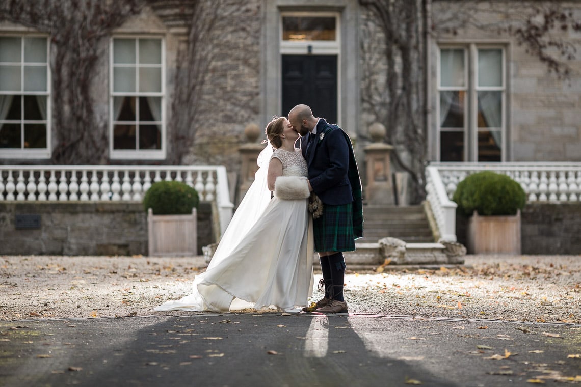 newlyweds kissing at the front of the building