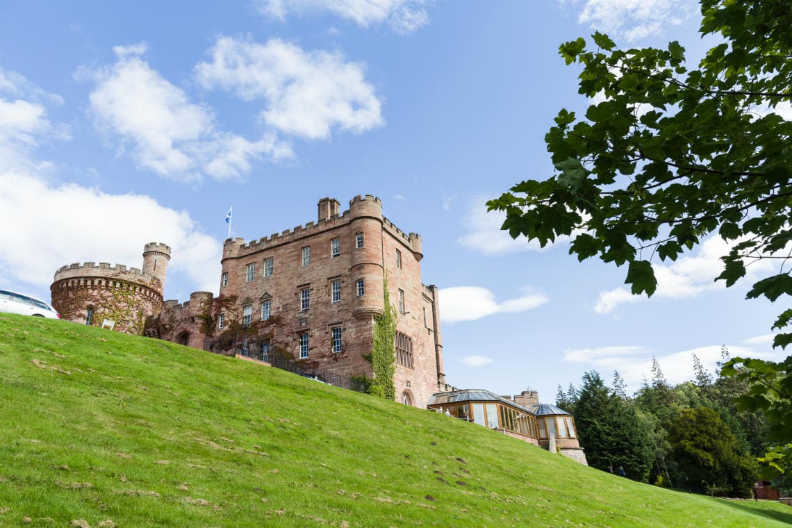 Castle exterior view from the grassy hill