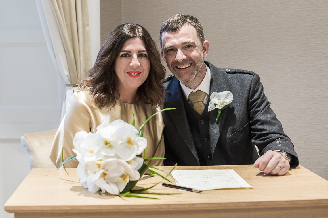 Edinburgh City Chambers wedding photographer image of newlyweds signing the marriage schedule