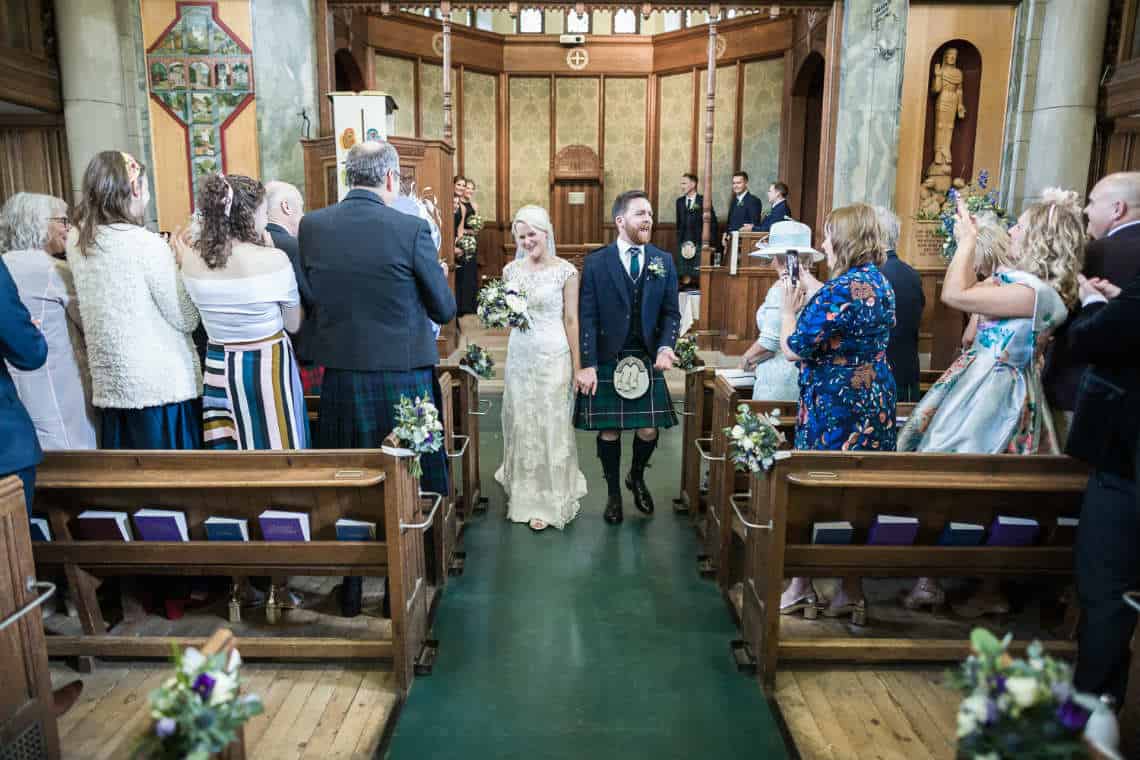 Newlyweds walking down the aisle of the church