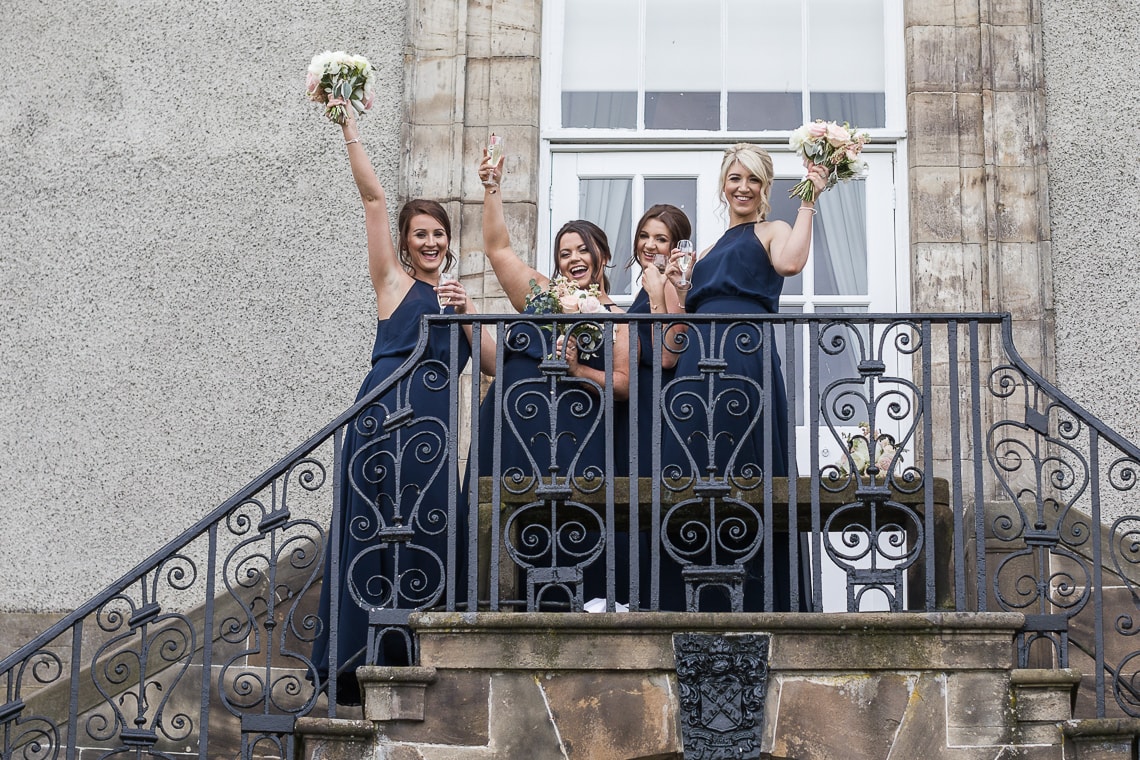 bridesmaids standing on the steps above the cocktail bar