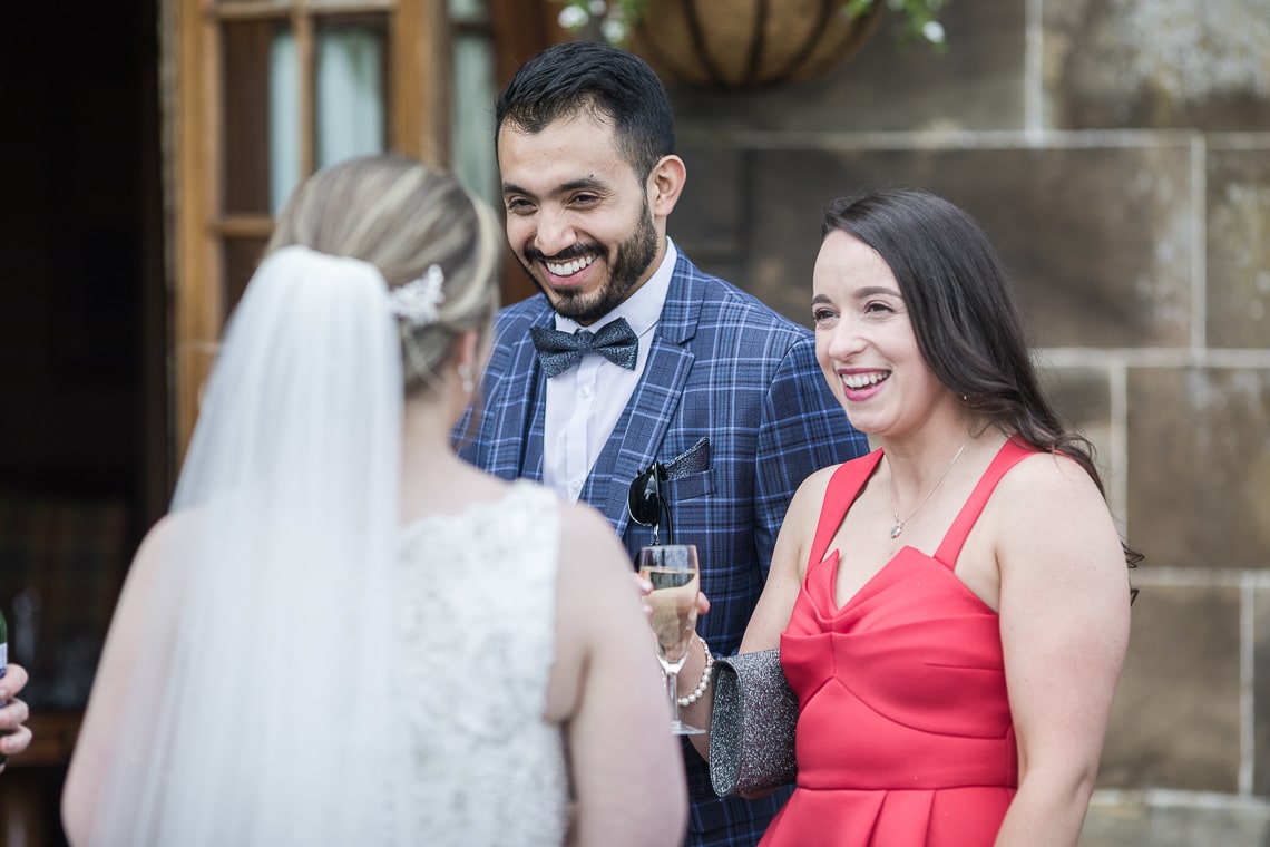 wedding guest couple chatting with the bride