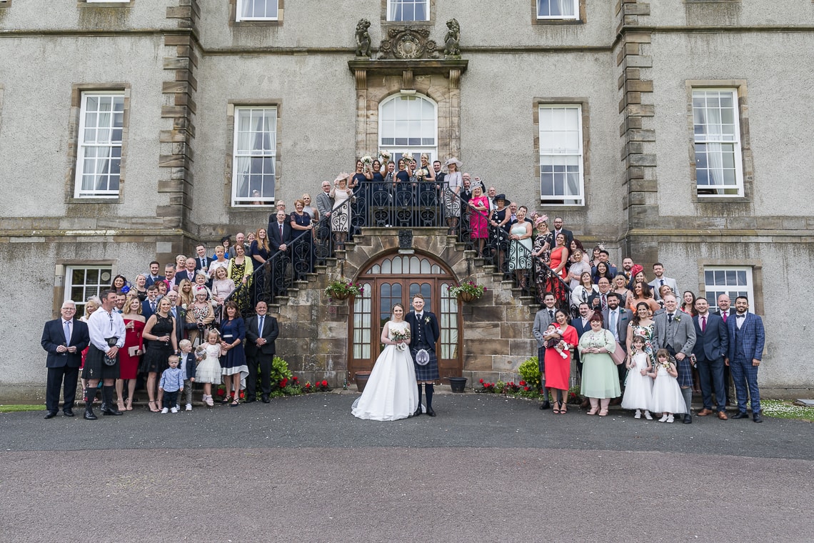 group photo of everyone on the steps at the rear of the hotel