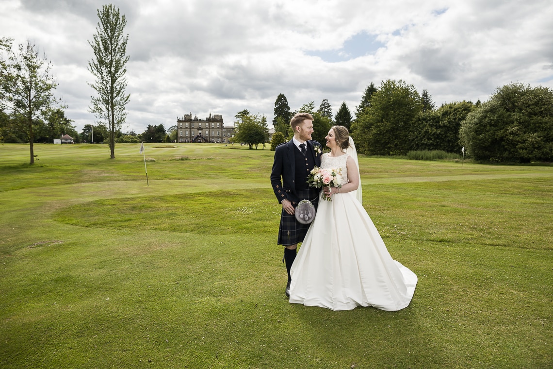 bride and groom newlywed photo with Dalmahoy Hotel in the background