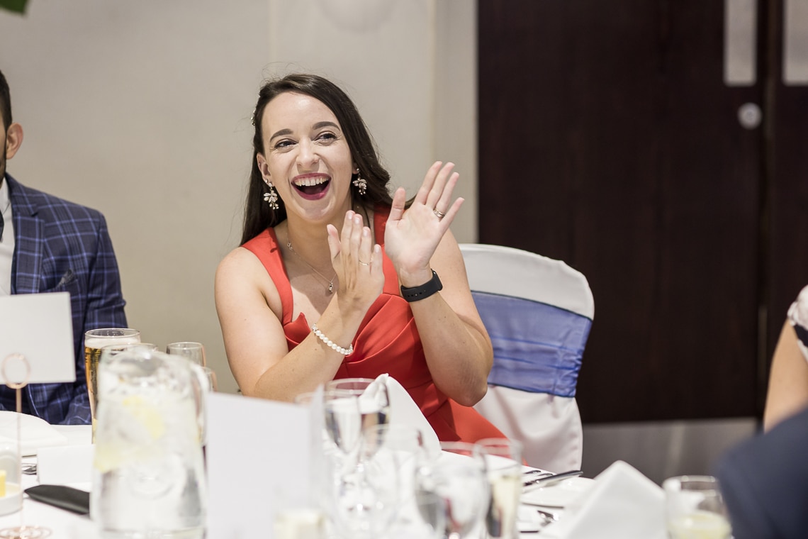 female guest laughing during wedding speech