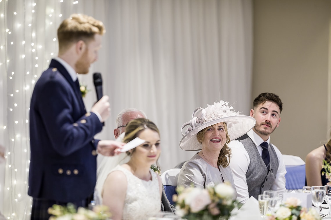 mother of the bride laughing during the groom speech