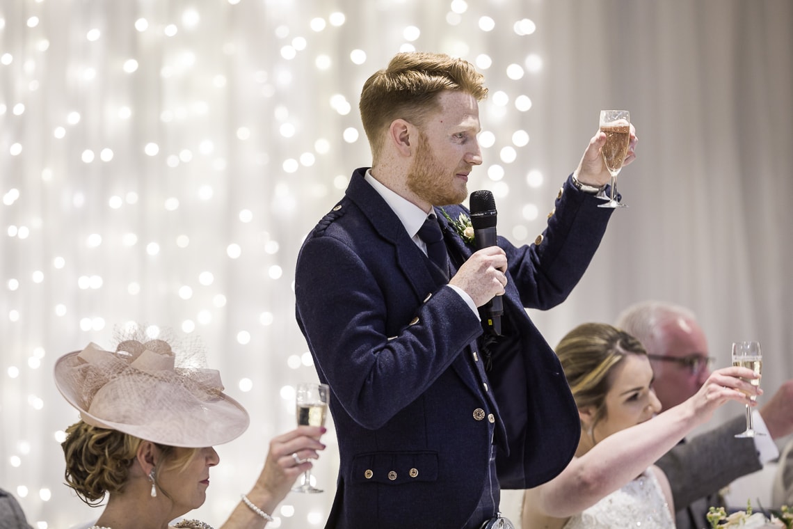 groom raises a toast during his speech