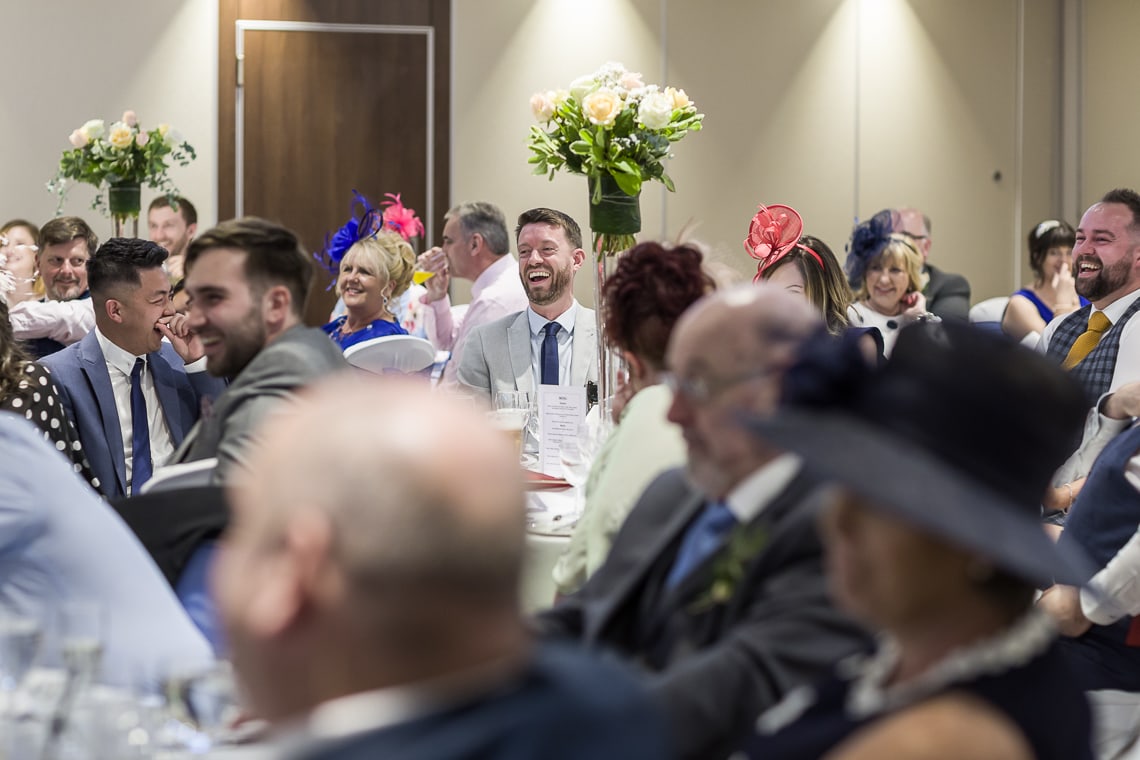 guests laughing during best men speech