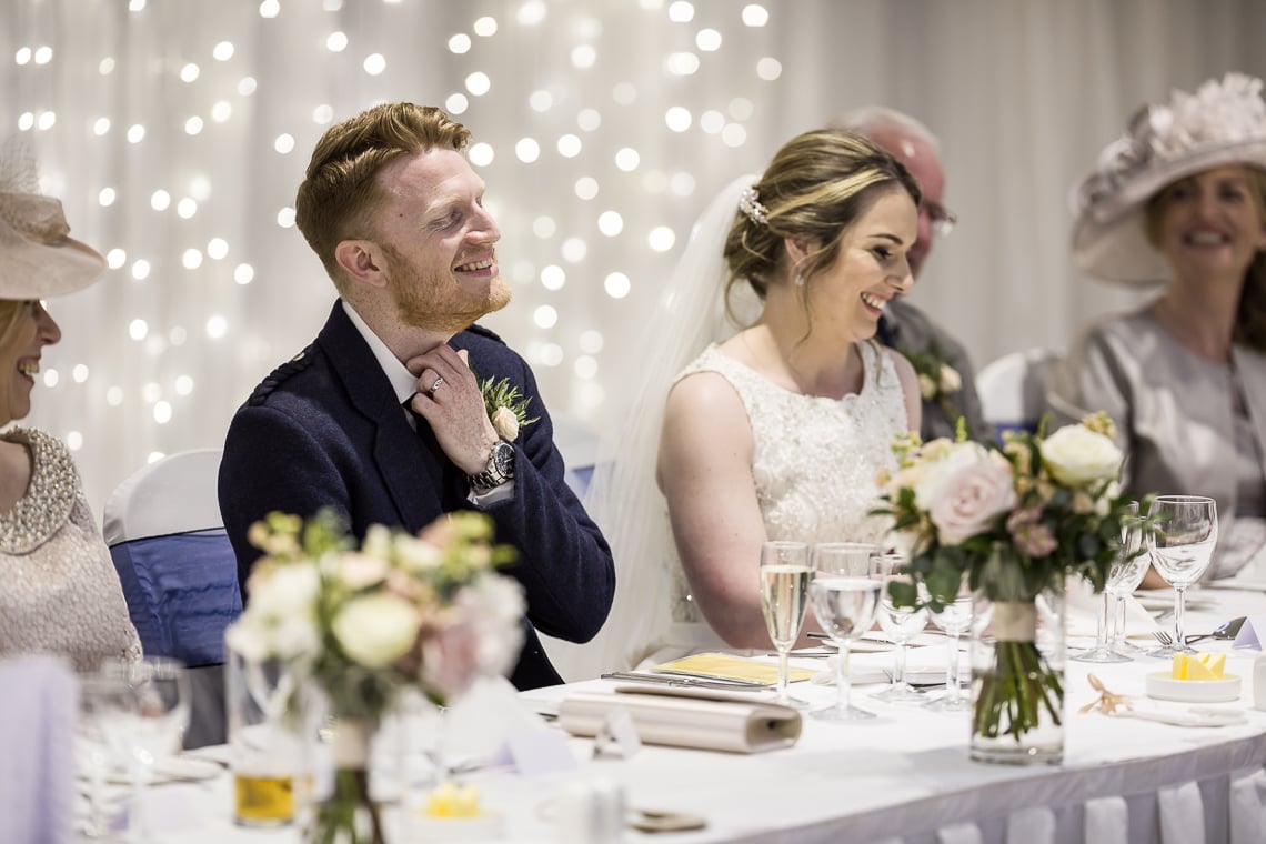 groom nervously listens to best men speech