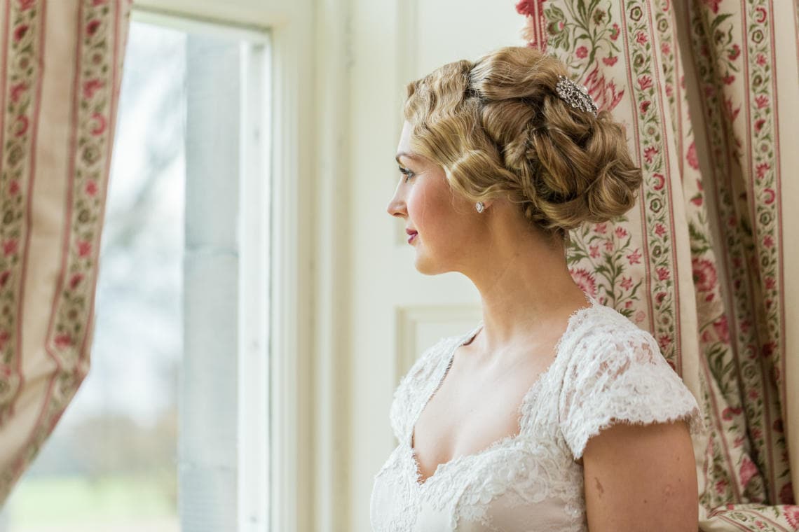 profile portrait of bride looking out of the window in the Winter bedroom