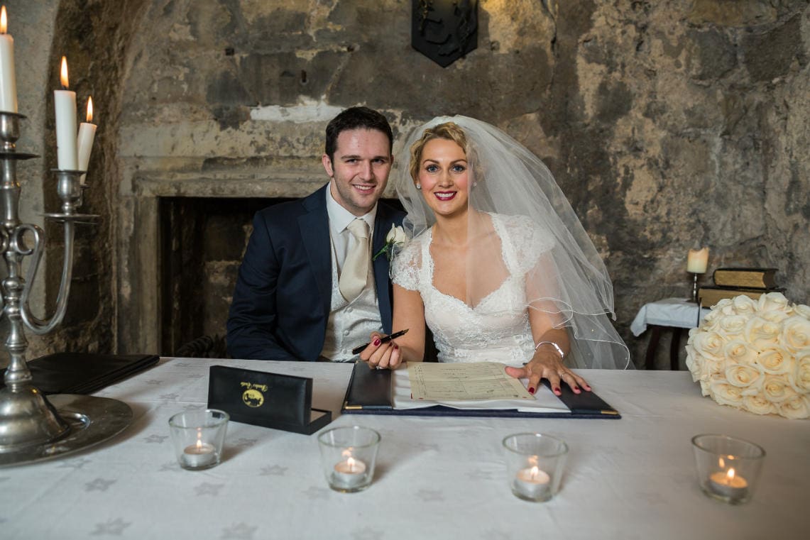 newlyweds signing the marriage schedule in the Auld Keep annex