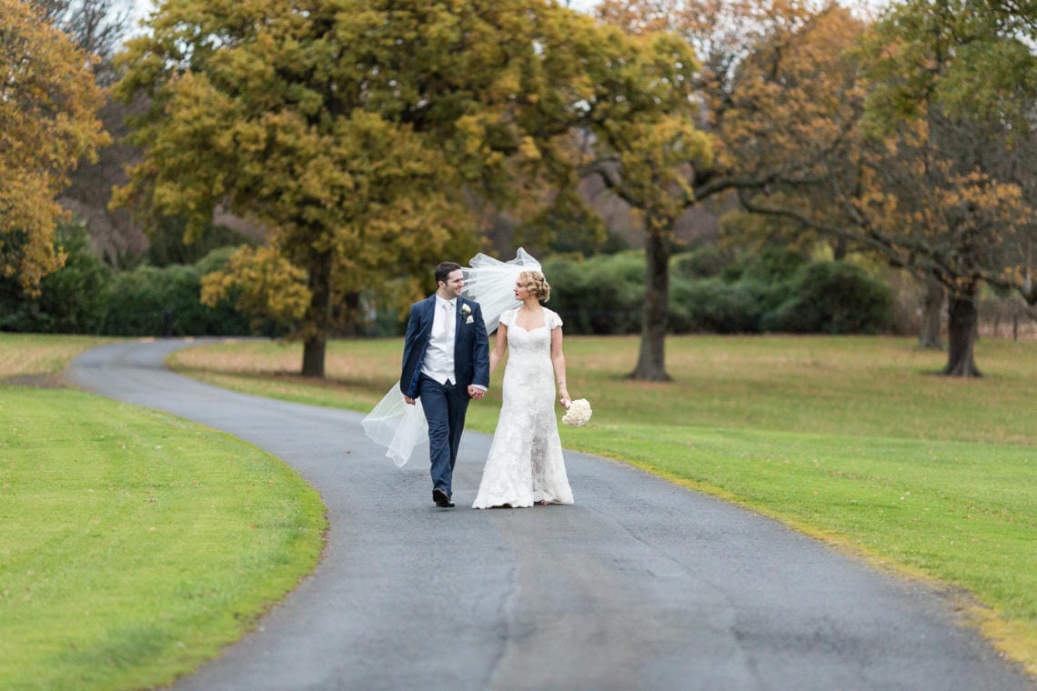 newlyweds walking along the driveway