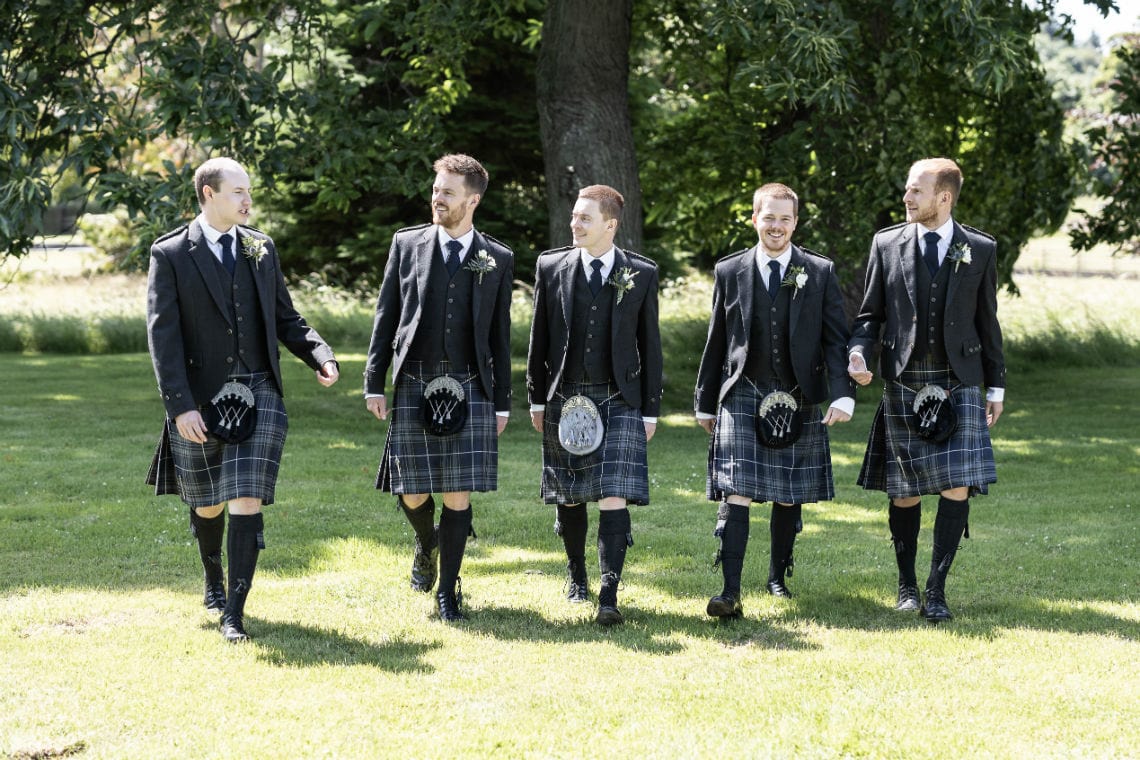 groom and groomsmen walking towards the camera