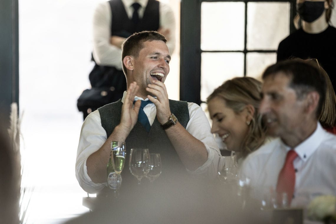 male guest stands and applauds the newlyweds