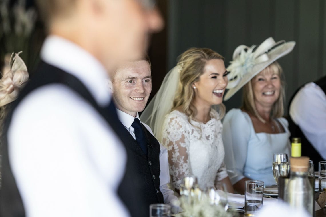 newlyweds laughing at the top table