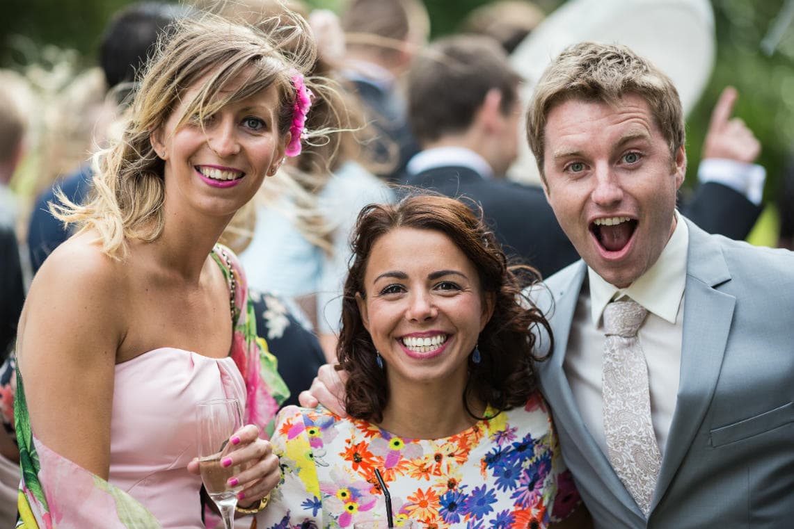 guests smiling for the camera during the drinks reception on the lawn