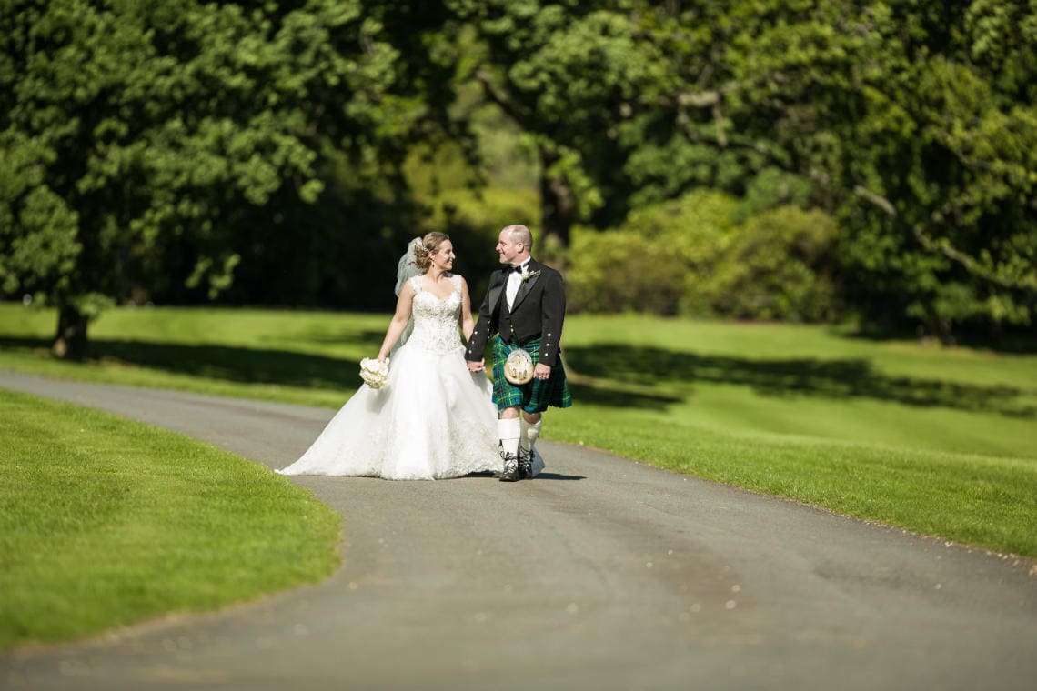 Gardens newlyweds walking along the driveway