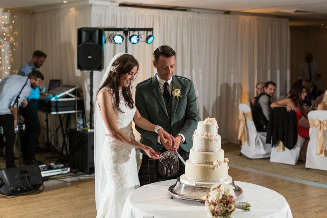 newlyweds cutting the cake in the Dalmahoy Suite