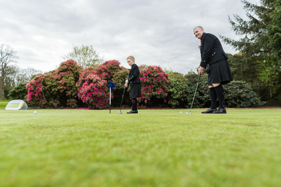 Golf course and grounds - groom and son best man on the putting green