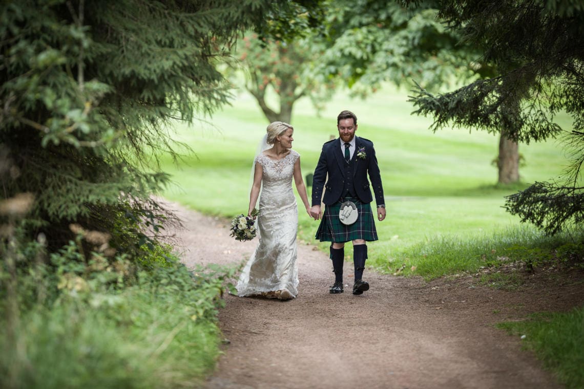 Golf course and grounds - newlyweds walking holding hands in the woods