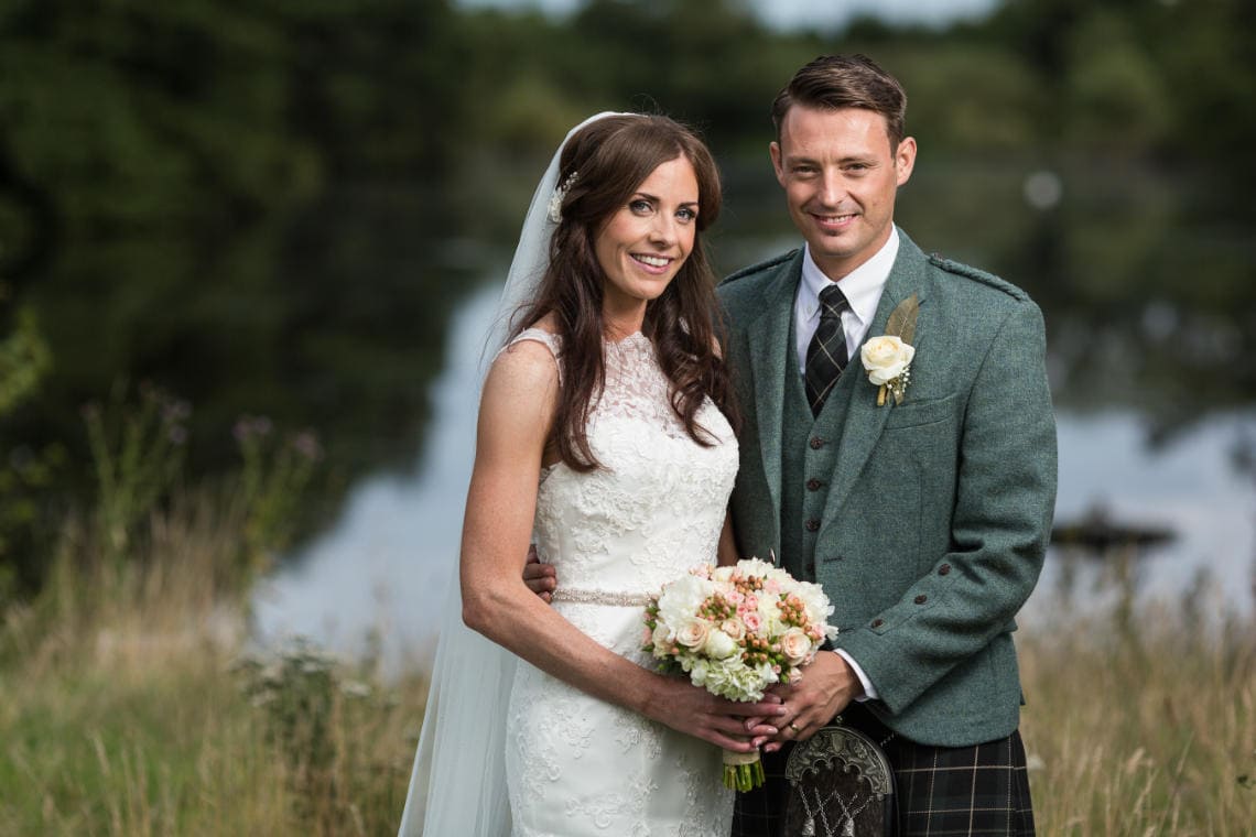 Golf course and grounds - newlyweds with the pond backdrop by Dalmahoy Hotel wedding photographer