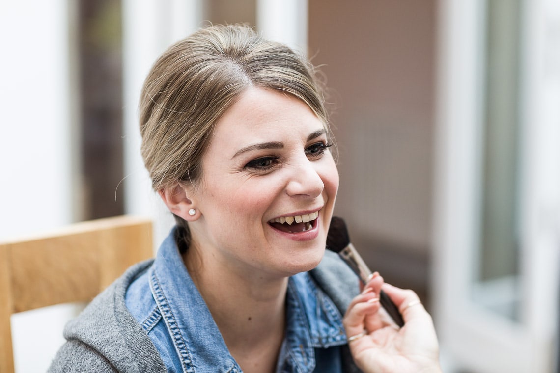 bridesmaid laughing while having makeup applied