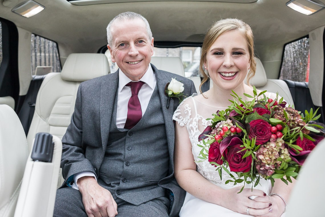 bride and her father sitting in the back fo a Range Rover wedding car
