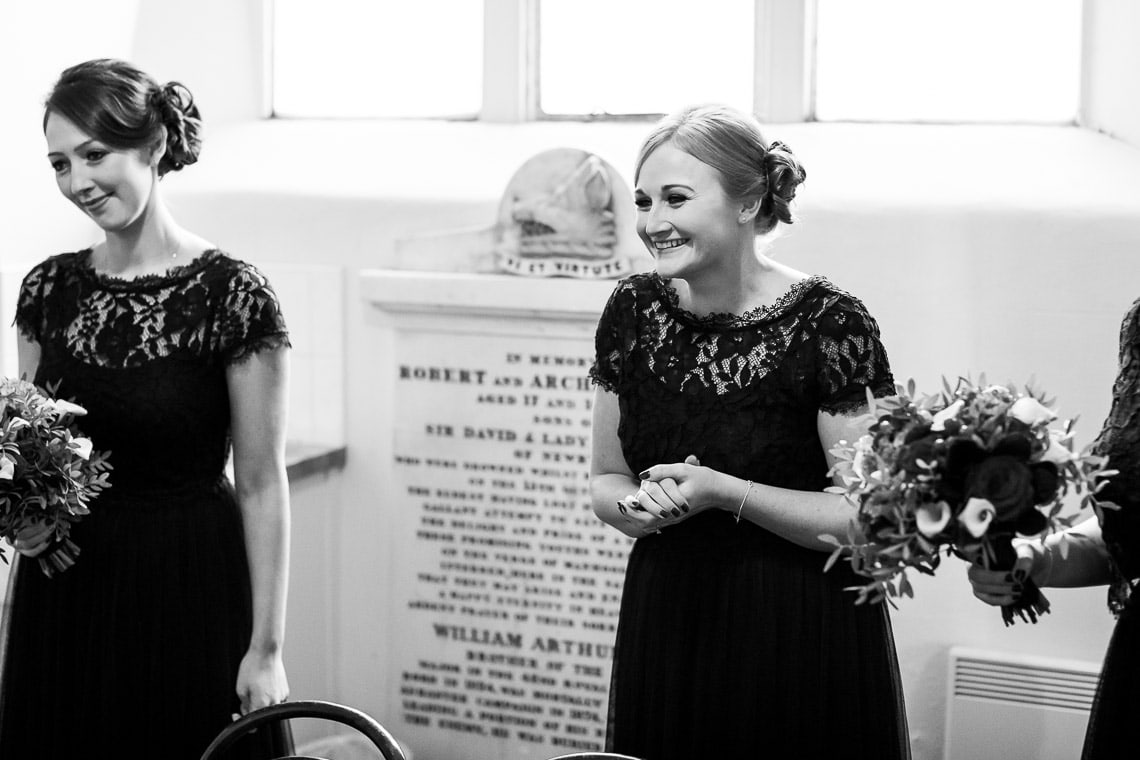 bridesmaid smiling at the bride before the ceremony begins