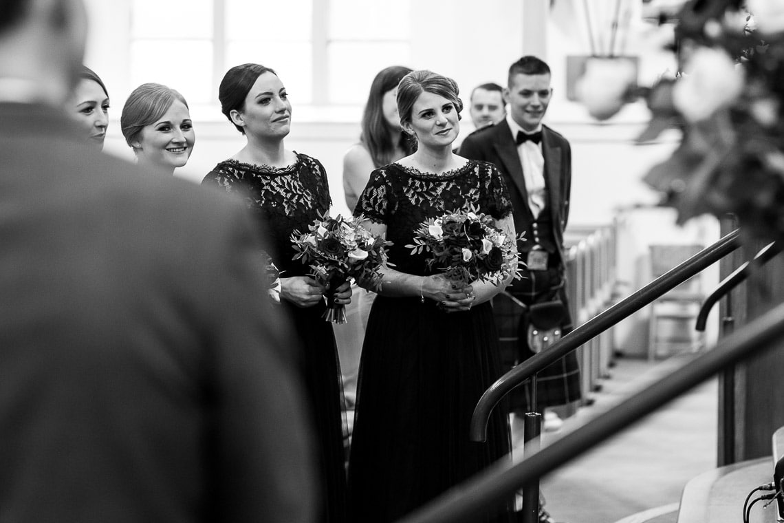 bridesmaids watching exchange of vows during ceremony at Liberton Kirk