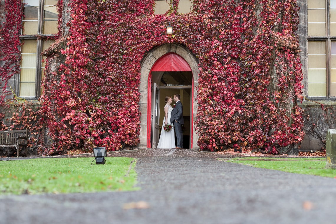 newlyweds embrace at the front door of Liberton Kirk