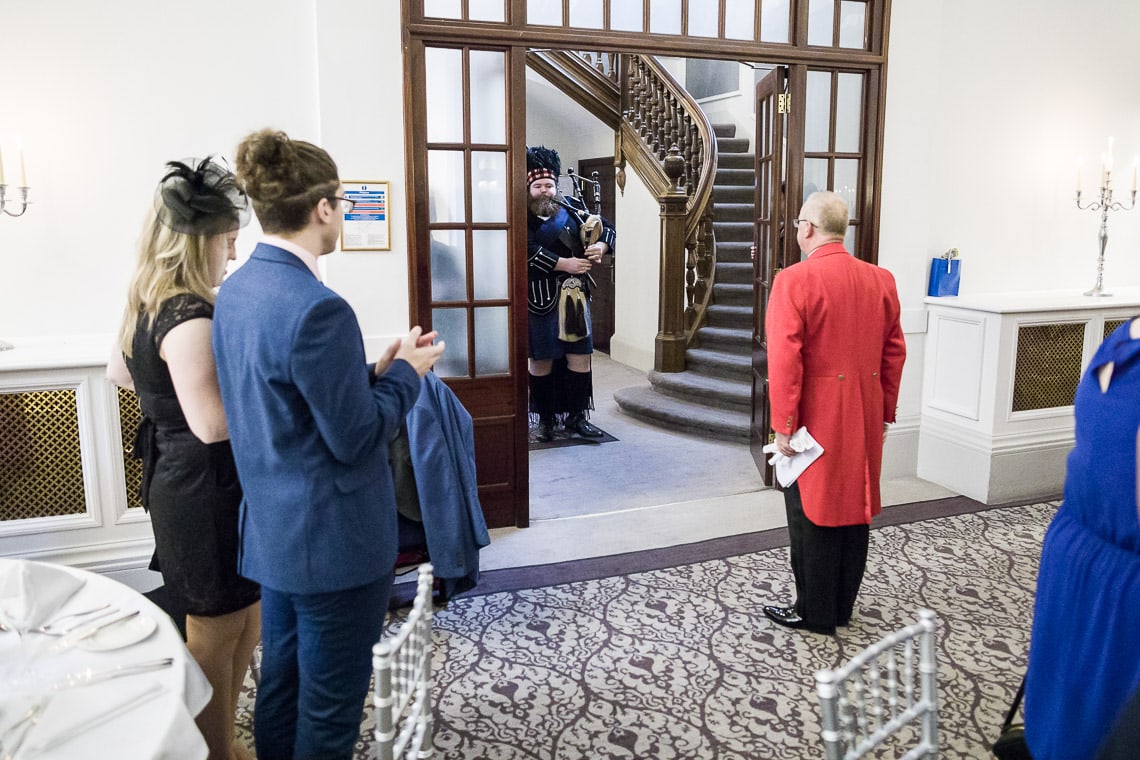 Toastmaster Maurice King leads the newlyweds as they enter the King's Hall