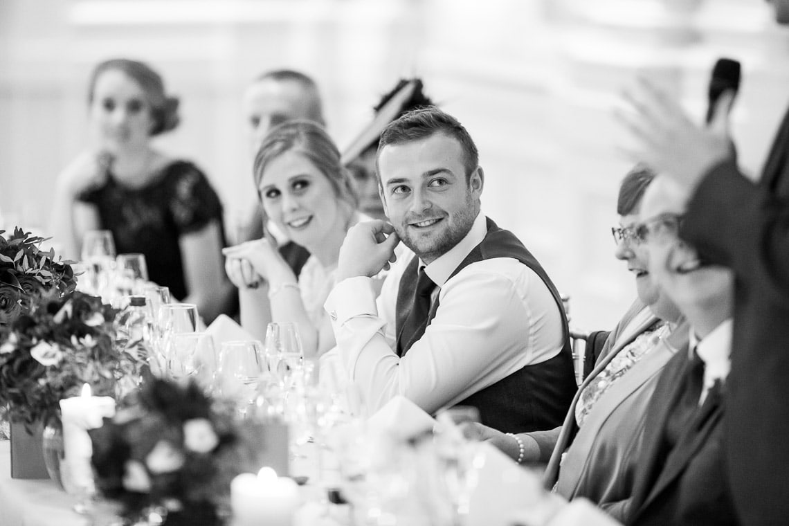 bride and groom watching groom's speech in the King's Hall