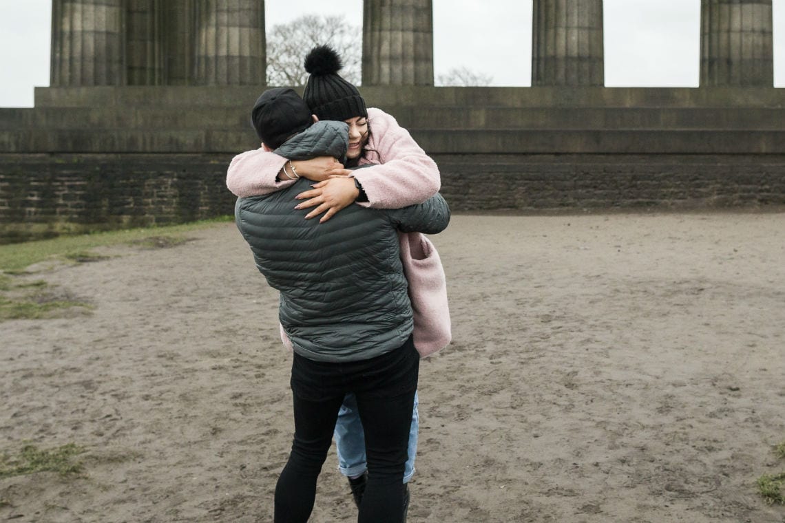 couple embrace after she agrees to marry him