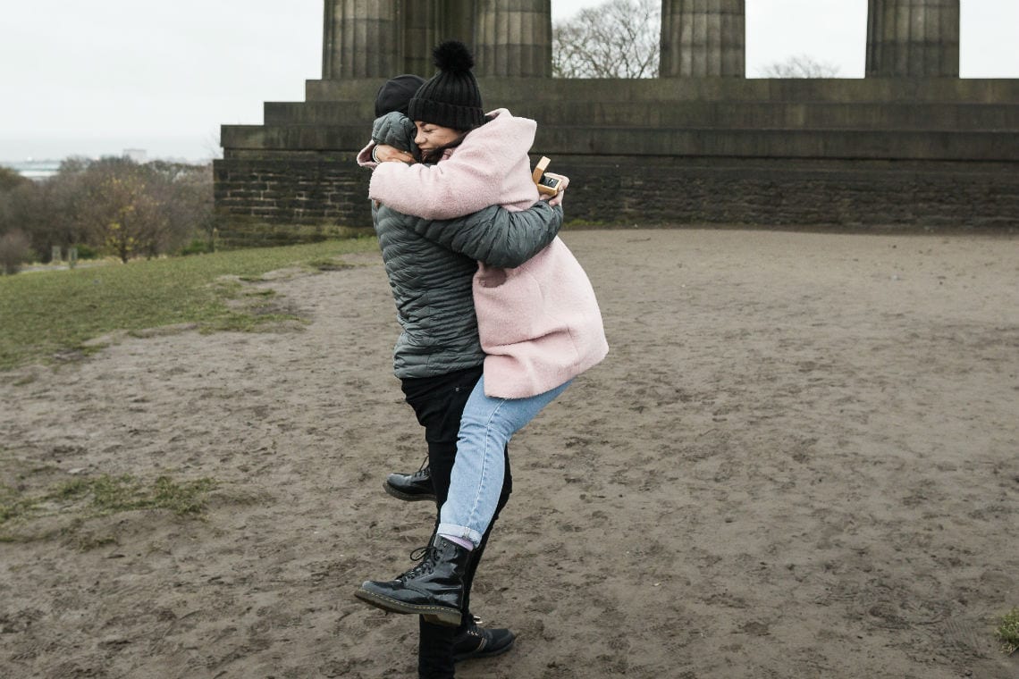 couple embrace after she agrees to marry him